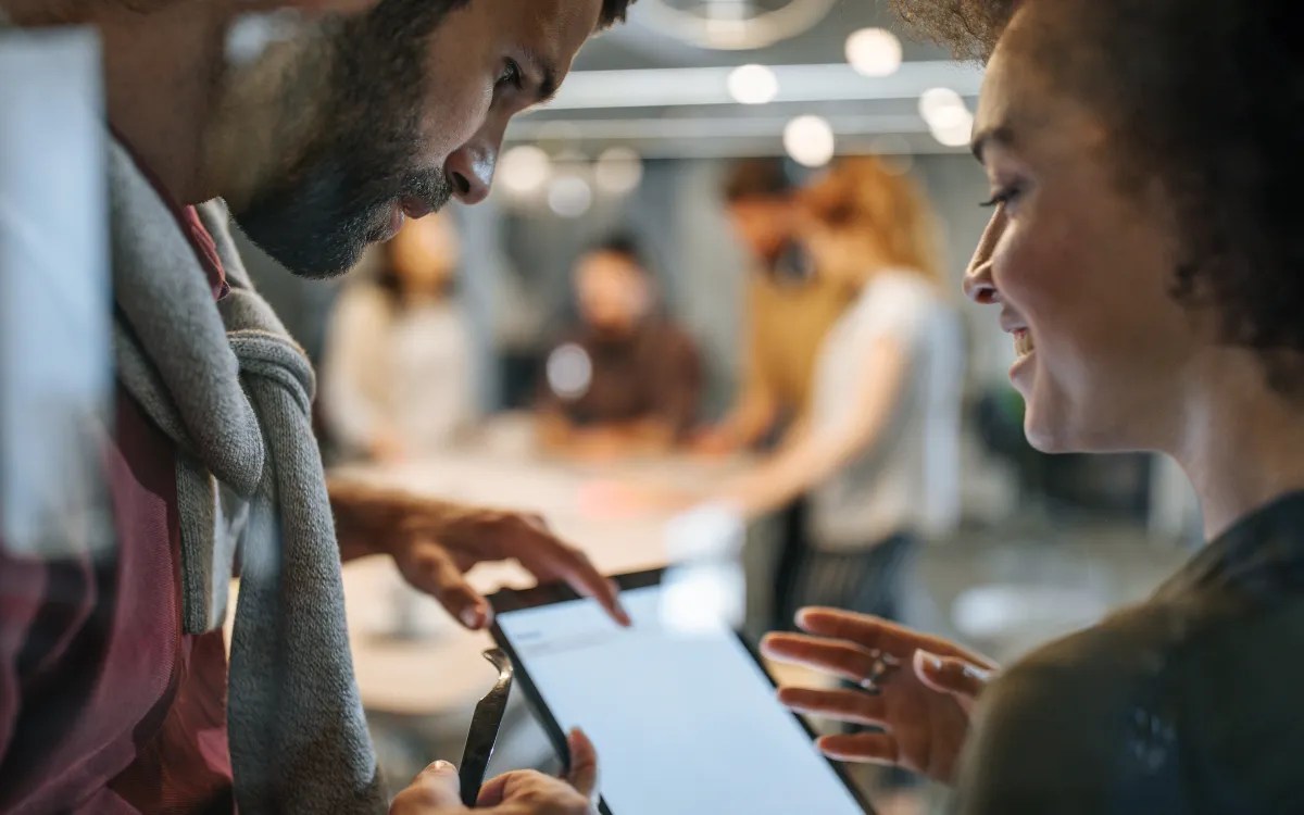 Colleagues reviewing content on a tablet in a modern office environment